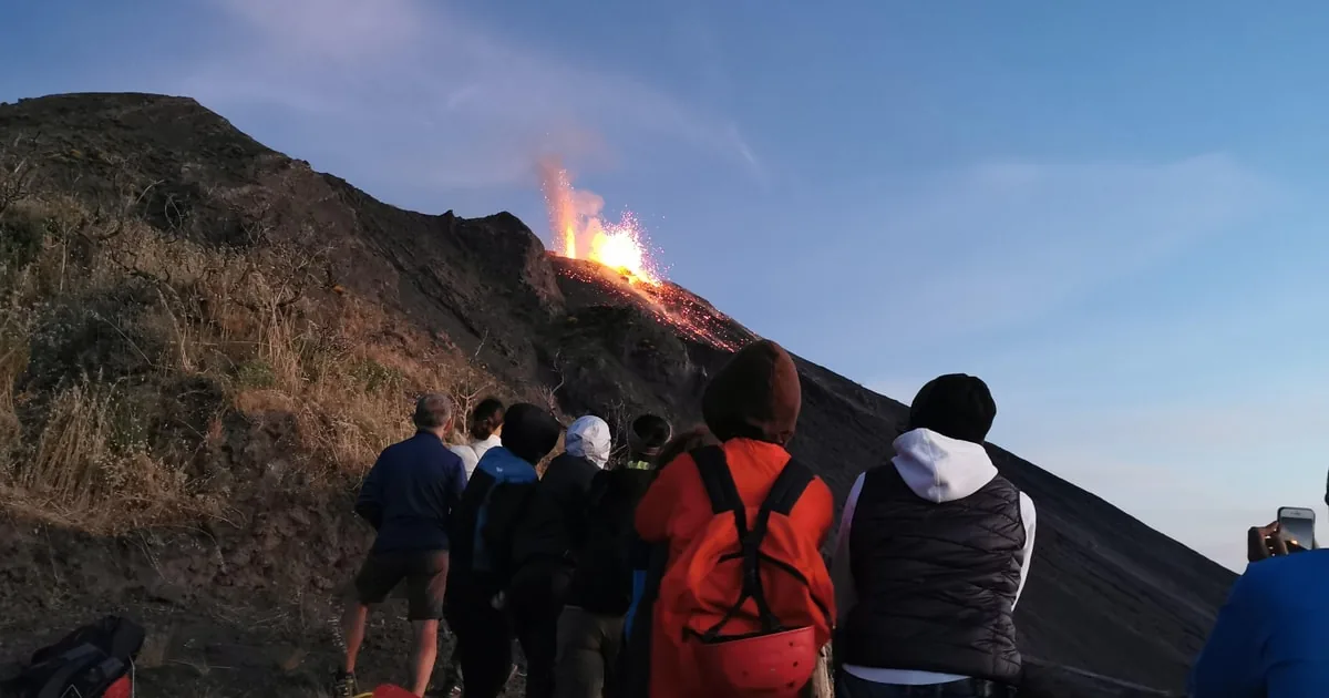 Guided sunset trekking group on the black scree slope of Sciara del Fuoco watching the Stromboli volcano eruptions on a Stromboli volcano tour, Aeolian Islands, Italy