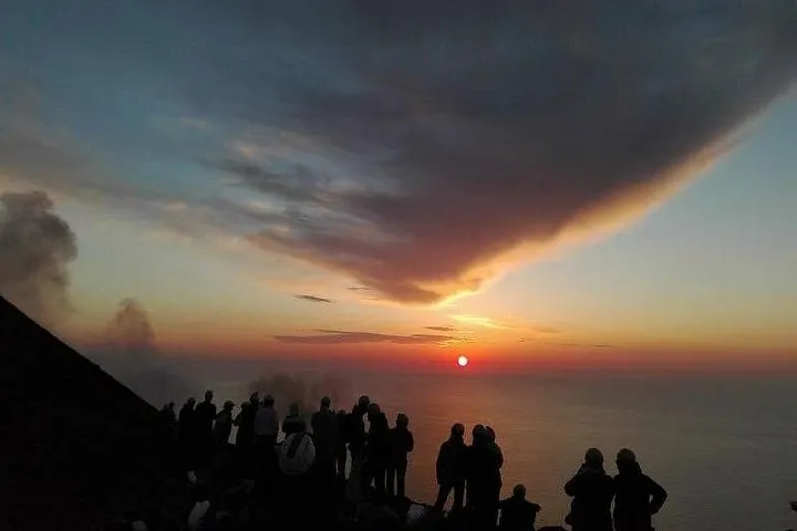 View across the Sciara del Fuoco towards the glowing craters of the Stromboli volcano at dusk on a sunset excursion, Aeolian Islands, Italy