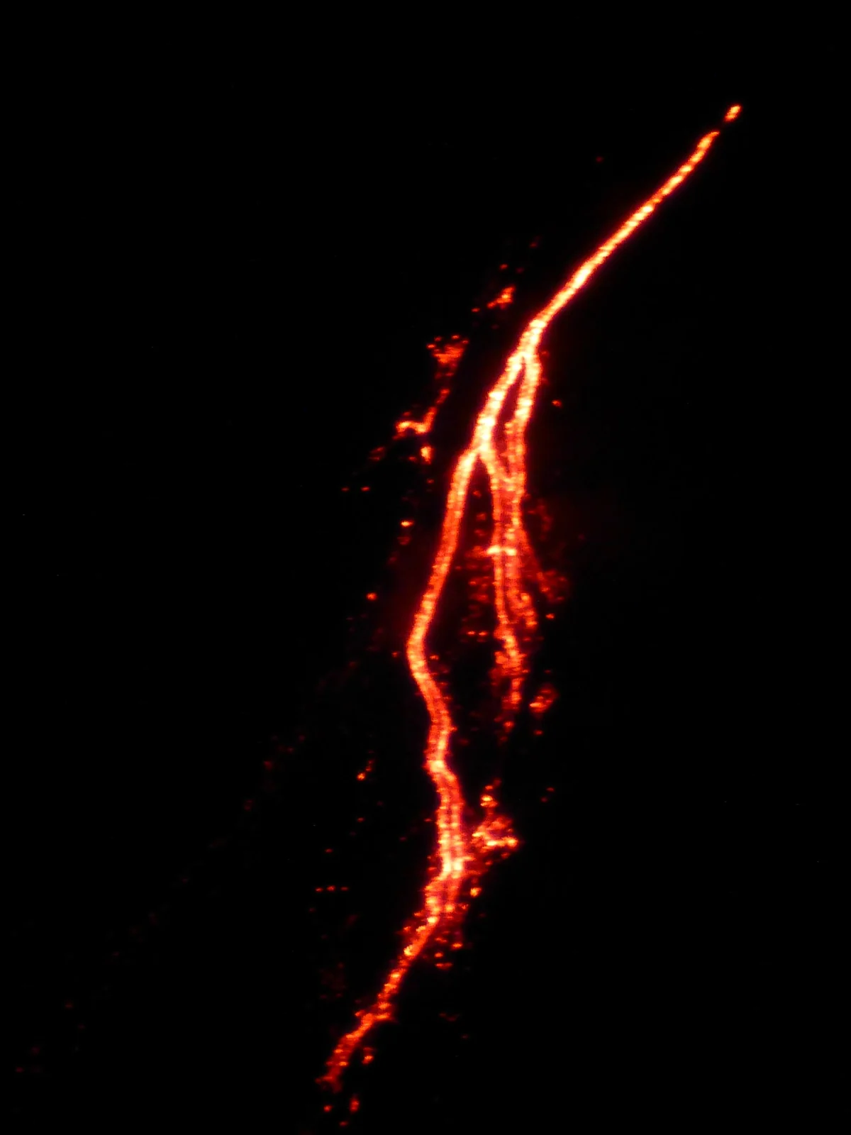 Night lava flow on the Stromboli volcano photographed from a ship's deck, Aeolian Islands, Italy